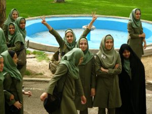 School girl in Iran waves peace sign.